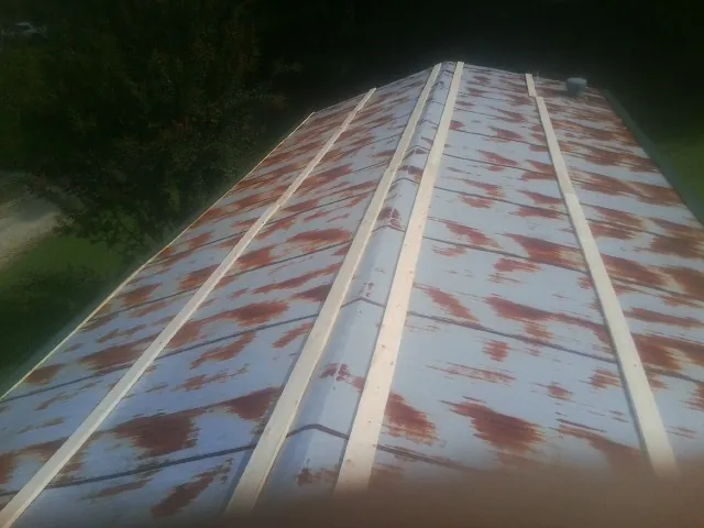 Rusted metal roof panels with new wood purlins before replacement — Storm Damage Roof Repair in Minford by Roofing Brothers